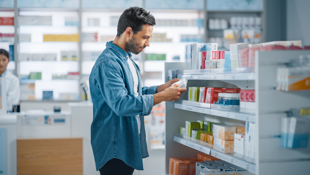 Man looking at medications in pharmacy