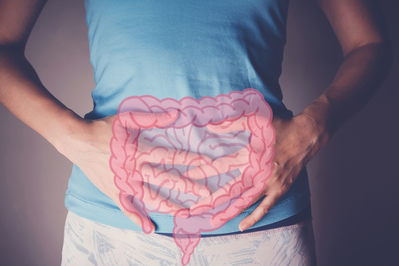 woman holding stomach with diagram of digestive tract